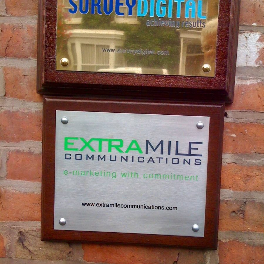 Extra Mile Communications silver wall sign