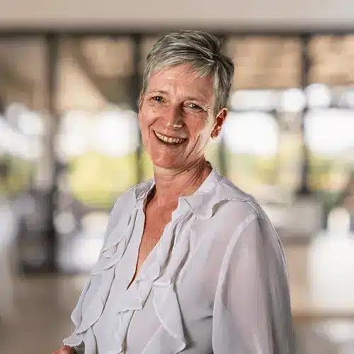 Headshot of Managing Director Amanda, smiling against blurred office background