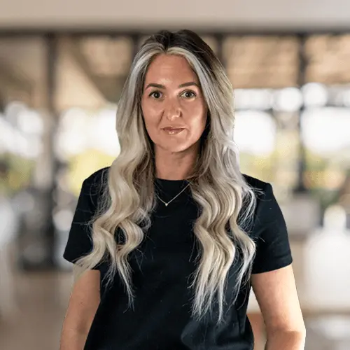 Headshot of team member Jene, smiling against blurred office background