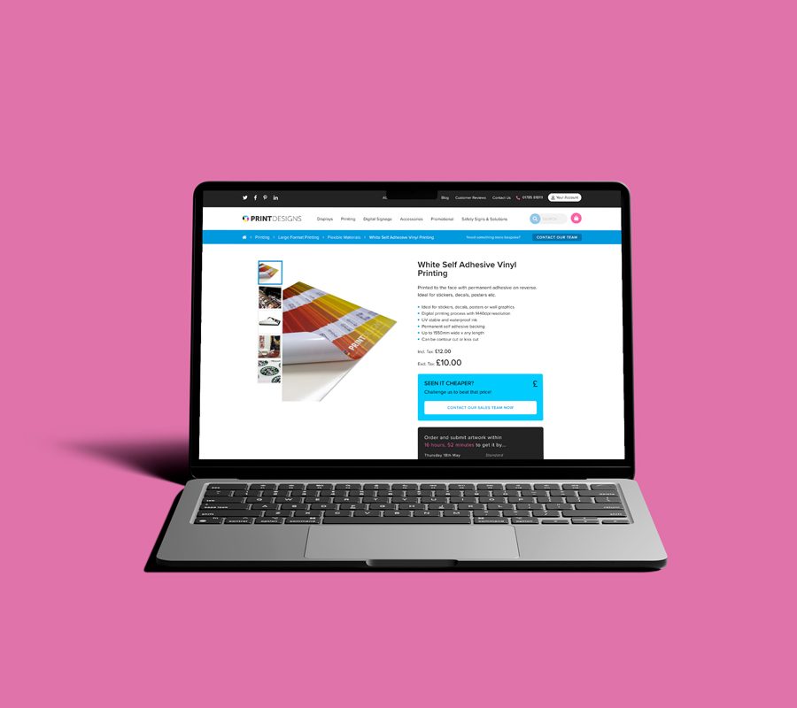 Open laptop on a pink background, displaying a webpage from the Print Designs website.