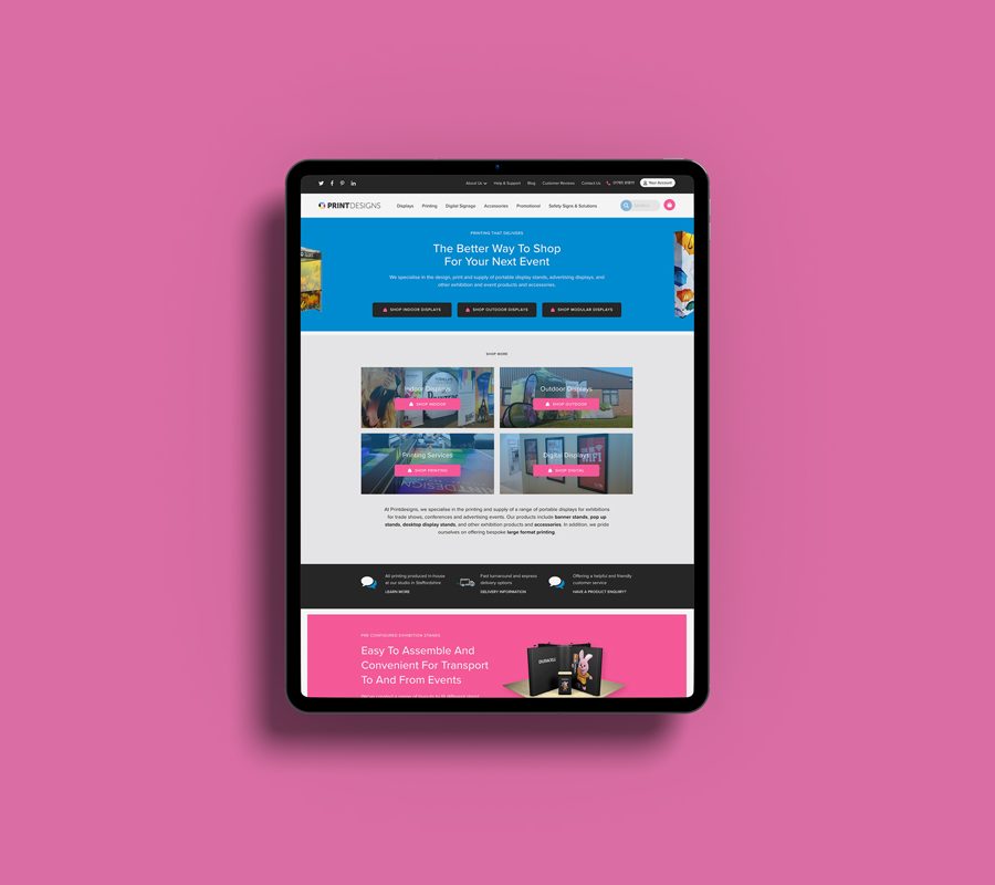 Tablet device on a pink background, displaying a webpage from the Print Designs website.