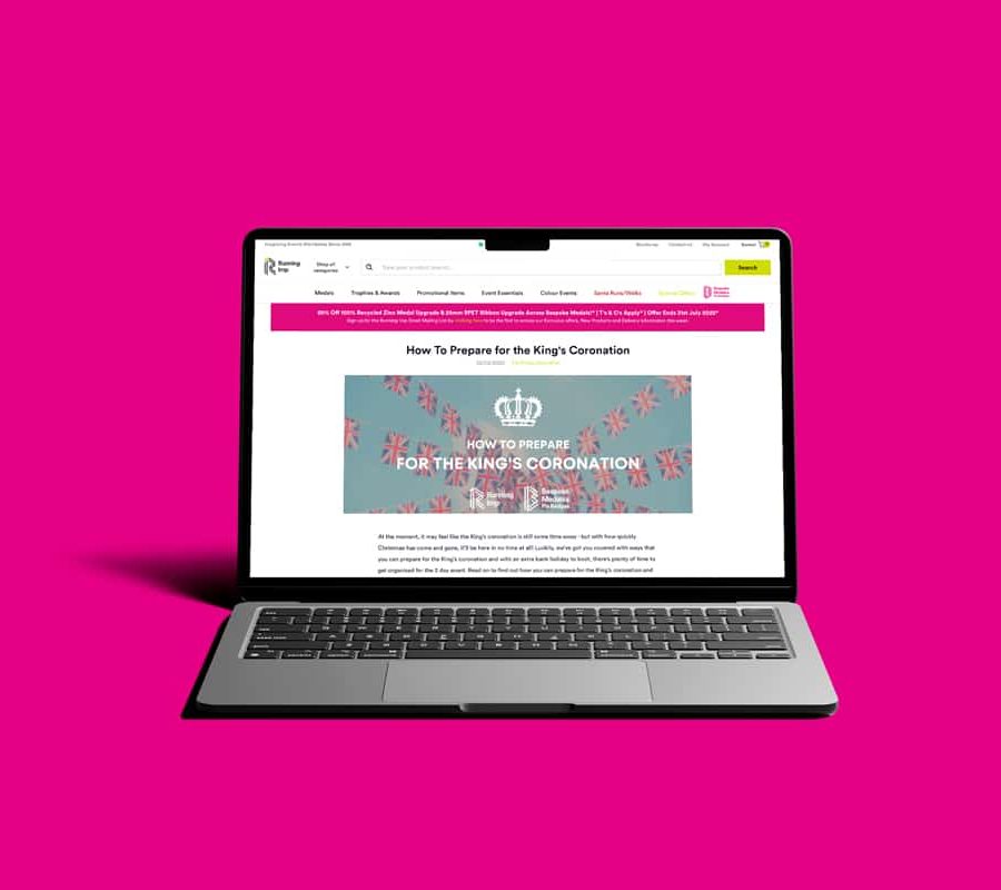 Laptop displaying Running Imp website, against pink background