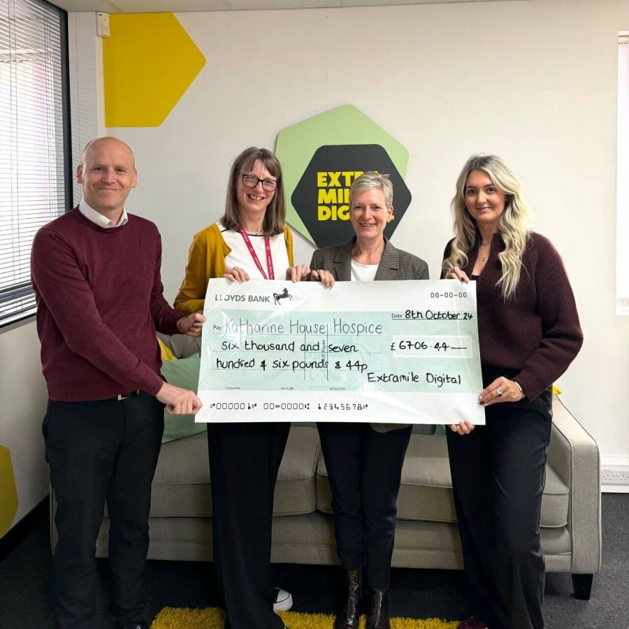 Group presenting a charity cheque for Katharine House Hospice inside the EMD office